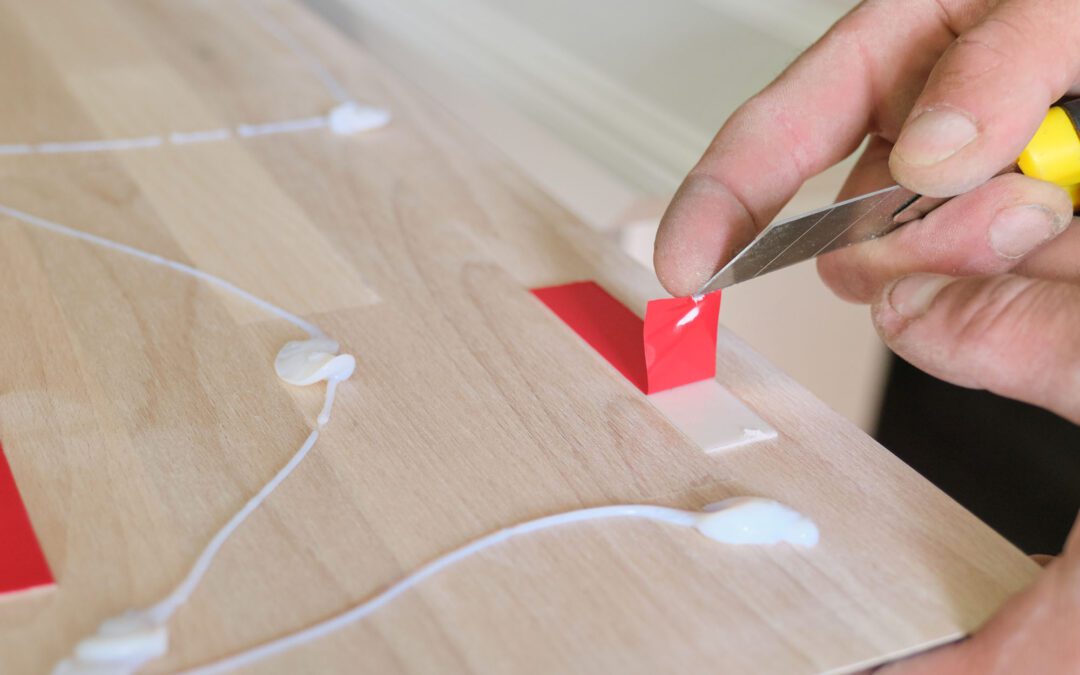 A carpenter using construction glue and double sided tape for a home renovation project